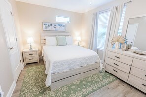 A bedroom with a bed, bedside tables, a dresser, a window with curtains, and a painting on the wall. - *NEW* Villa De Madera~Dock!~Pool!~Kayaks!~Grill! (Marathon)