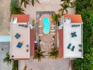 An aerial view of a resort with a central swimming pool, lounge areas, and palm trees. - *NEW* Villa De Madera~Dock!~Pool!~Kayaks!~Grill! (Marathon)