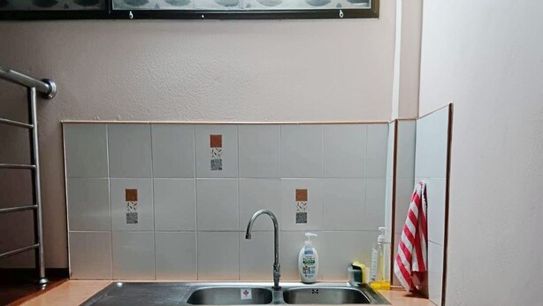 A bathroom with a sink, mirror, and towel rack.