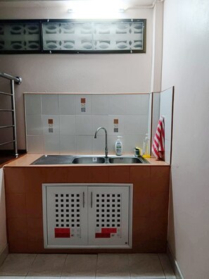 Baño con lavamanos, espejo y toallero.