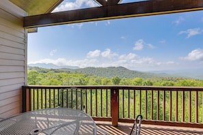 A balcony with a metal table and chair, overlooking a mountainous landscape. - Luxury Above the Clouds | Walk to the Slopes | 2BR  Loft | 3 Baths | Sleeps 6 (Sugar Mountain)