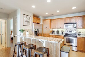 A kitchen with wooden cabinets, stainless steel appliances, and a marble countertop. - Luxury Above the Clouds | Walk to the Slopes | 2BR  Loft | 3 Baths | Sleeps 6 (Sugar Mountain)