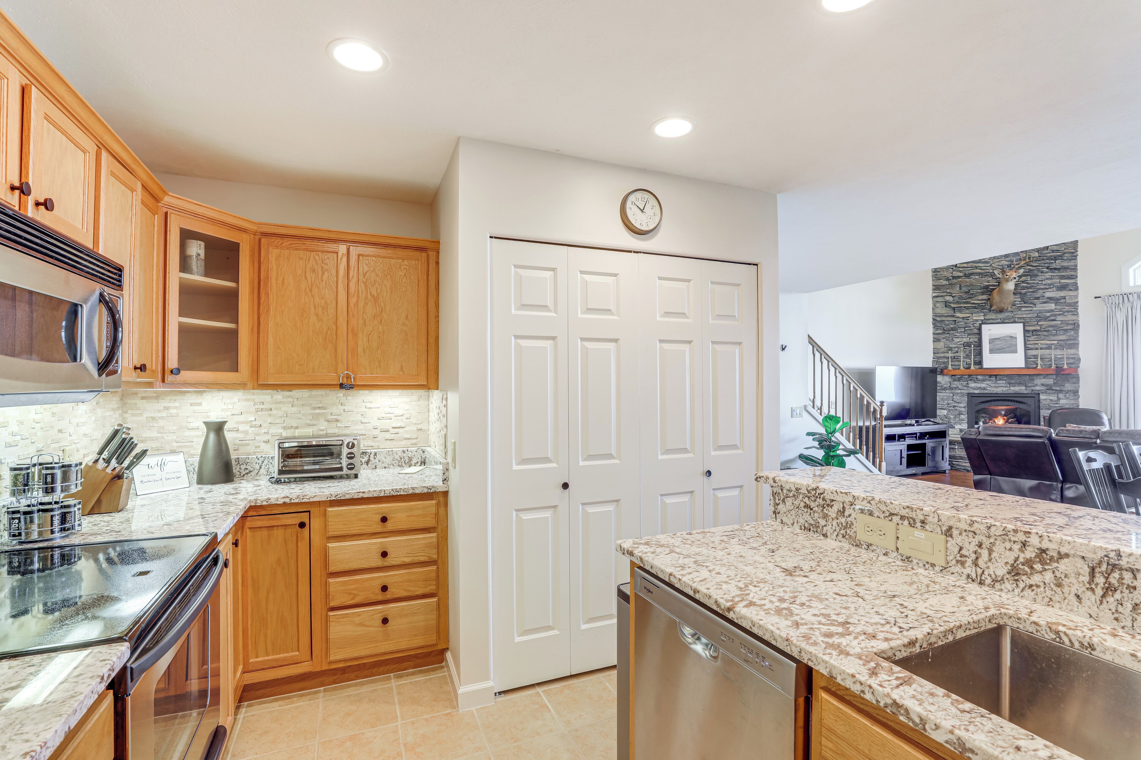 A kitchen with wooden cabinets, a microwave, a toaster, and a dishwasher.