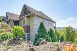 A two-story house with a sloped roof, a stone foundation, and a front porch. - Luxury Above the Clouds | Walk to the Slopes | 2BR  Loft | 3 Baths | Sleeps 6 (Sugar Mountain)