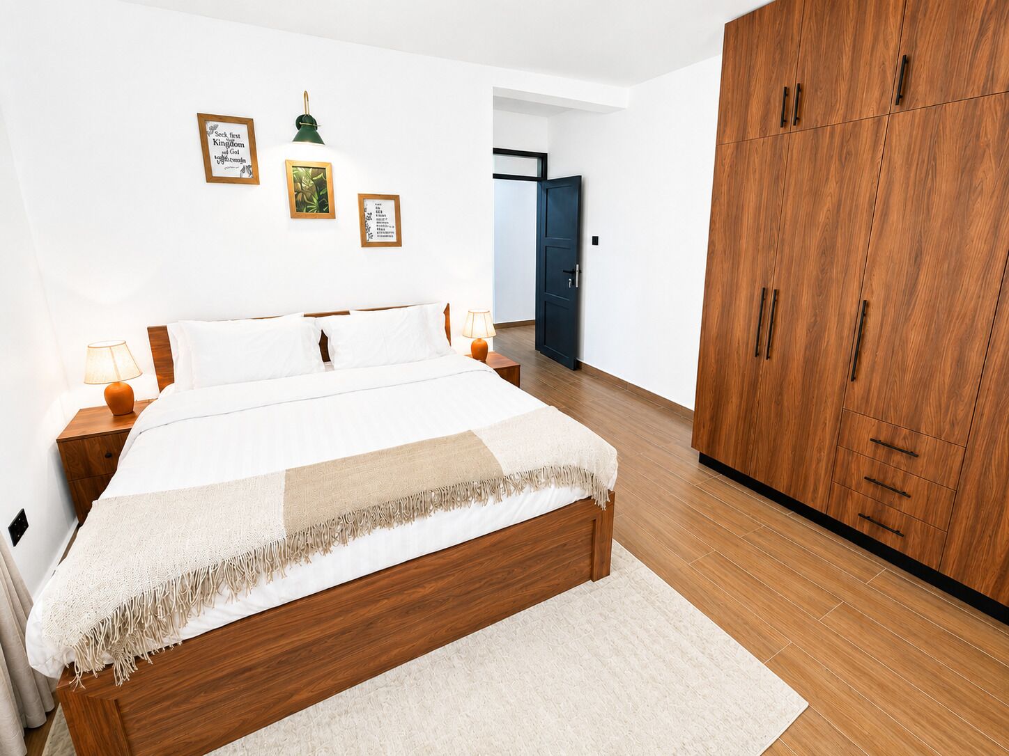 Ein Schlafzimmer mit einem großen Bett, einem Holzschrank und Wandbildern.