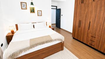 Ein Schlafzimmer mit einem großen Bett, einem Holzschrank und Wandbildern.