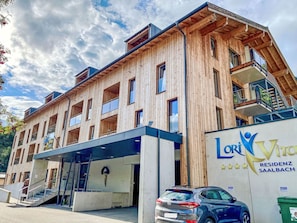 Un immeuble à plusieurs étages, doté d’un design moderne, qui combine des matériaux en bois et en béton.