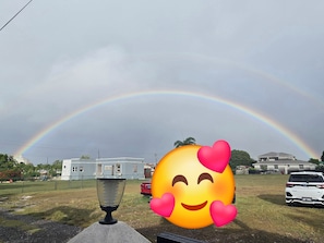 A residential area with a house, a parked car, and a visible rainbow. - Brilliant 1-bedroom apartment with AC in charming Oistins. Costline beaches near (Oistins)