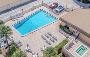 A rooftop swimming pool with lounge chairs and a small hot tub. - First Floor | Priv Beach | Pool & Pickleball (Cocoa Beach)