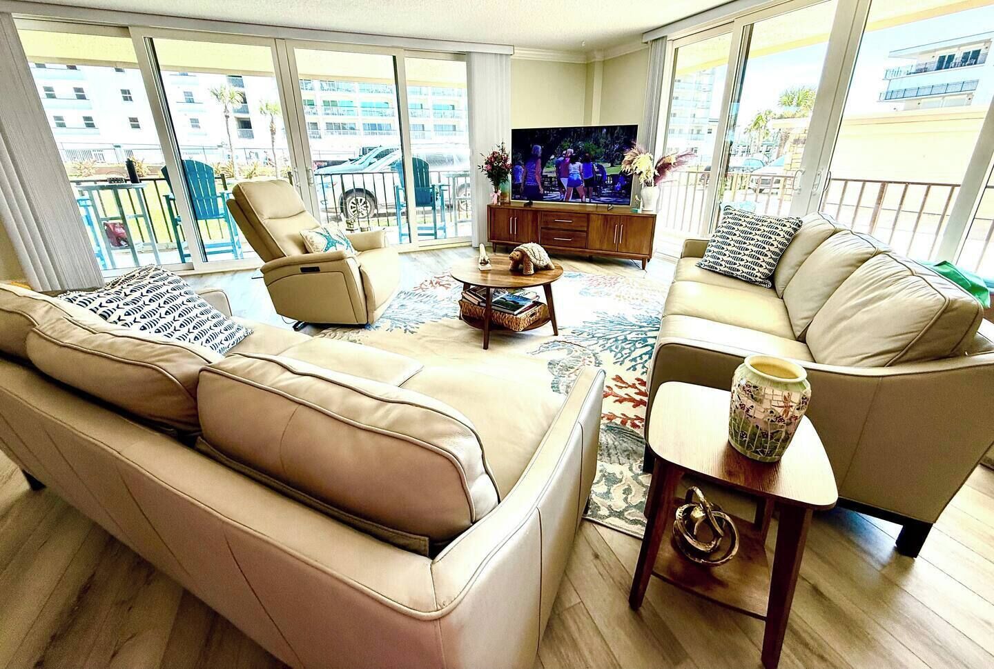 A spacious living room with a large sofa, a coffee table, and a television.