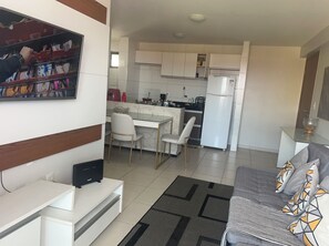 A modern living room with a sofa, a coffee table, and a TV stand. - Best in the Area, 2 bedrooms, suite, Excellent, close to the beaches. (Maceió)