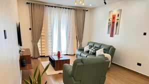 Una sala de estar moderna con un sofá verde, una mesa de centro y una planta en maceta.