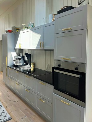 A kitchen with grey cabinets, a black countertop, and a Siemens oven. - Wooden house close to the sea in Hornbæk (Hornbæk)