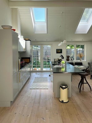 Una cocina moderna con tragaluces, piso de madera y vistas al exterior.
