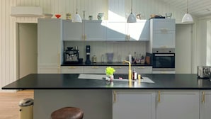 A modern kitchen with white cabinetry, a black countertop, and a skylight. - Wooden house close to the sea in Hornbæk (Hornbæk)