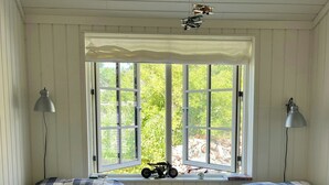 A room with two beds, a window with a view of greenery, and a radiator. - Wooden house close to the sea in Hornbæk (Hornbæk)