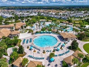 Ein Resort mit einem großen Pool im Zentrum, Liegestühlen und Blick auf die umliegende Gegend.