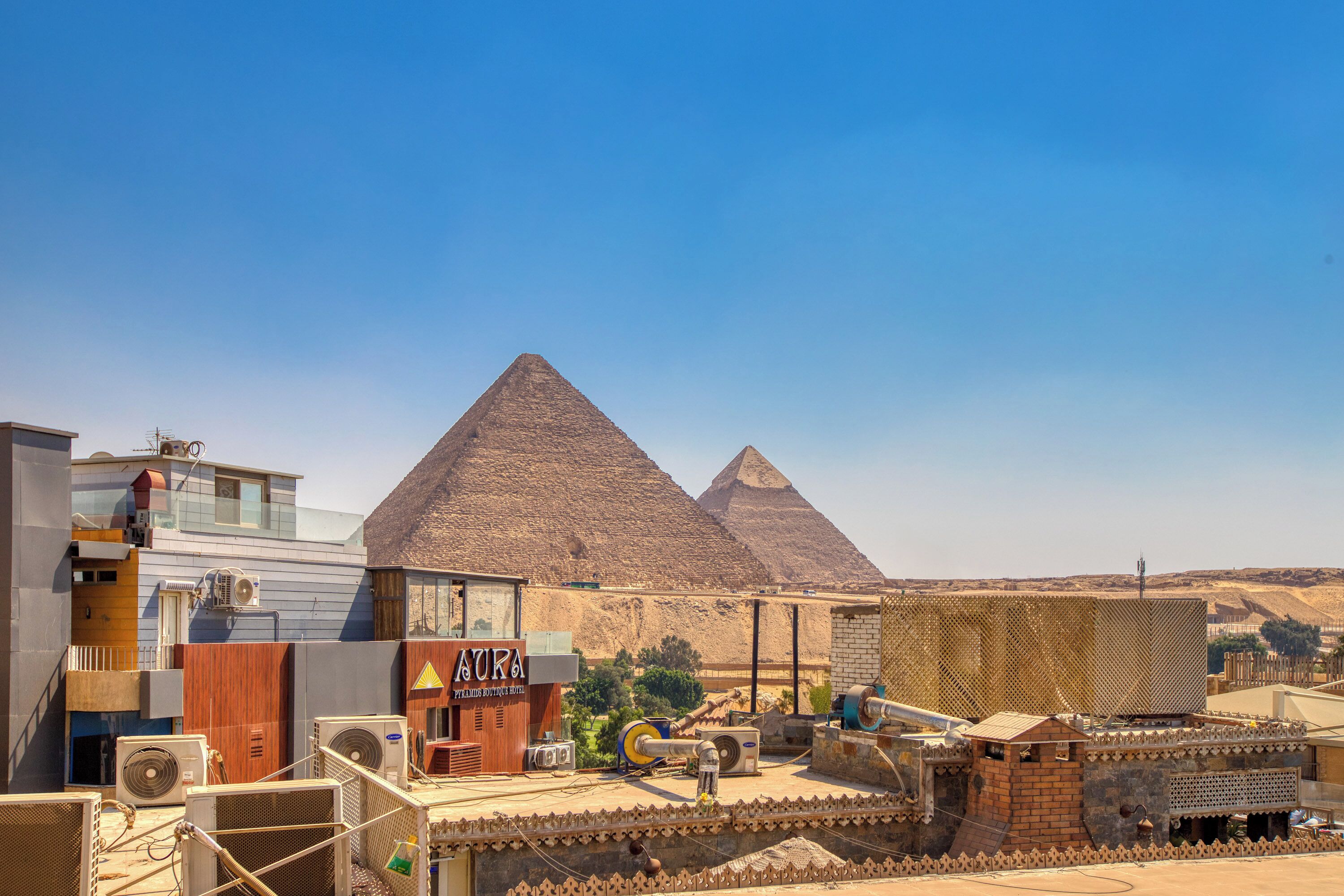Een hotel met een bordje 'Pyramids Boutique Hotel' voor de piramides.