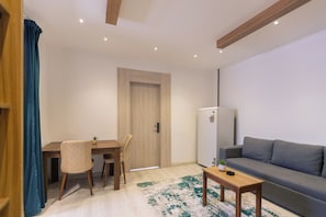 A compact living space with a dining area, a sofa, a small table, and a refrigerator. - My Pyramids View Inn Jacuzzi & Rooftop (Giza)