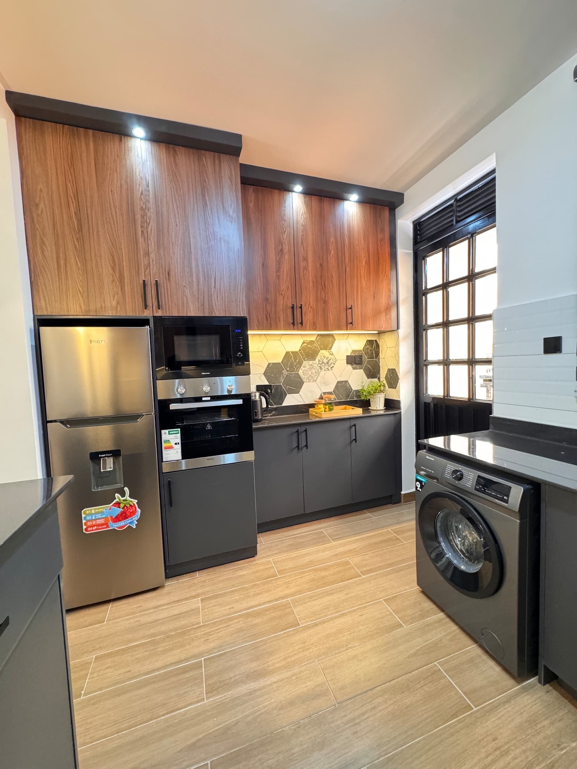 A modern kitchen with stainless steel appliances, wooden cabinets, and a built-in oven.