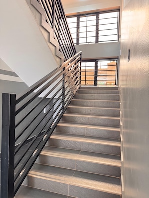 A staircase with a metal railing leading to an upper floor.
