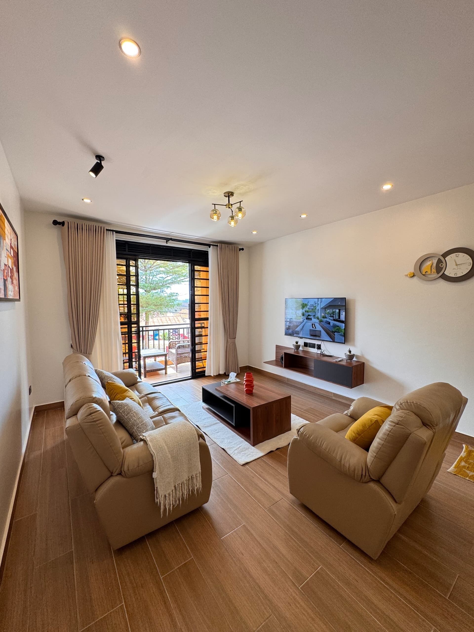 A modern living room with a sofa set, a coffee table, and a flat-screen TV.