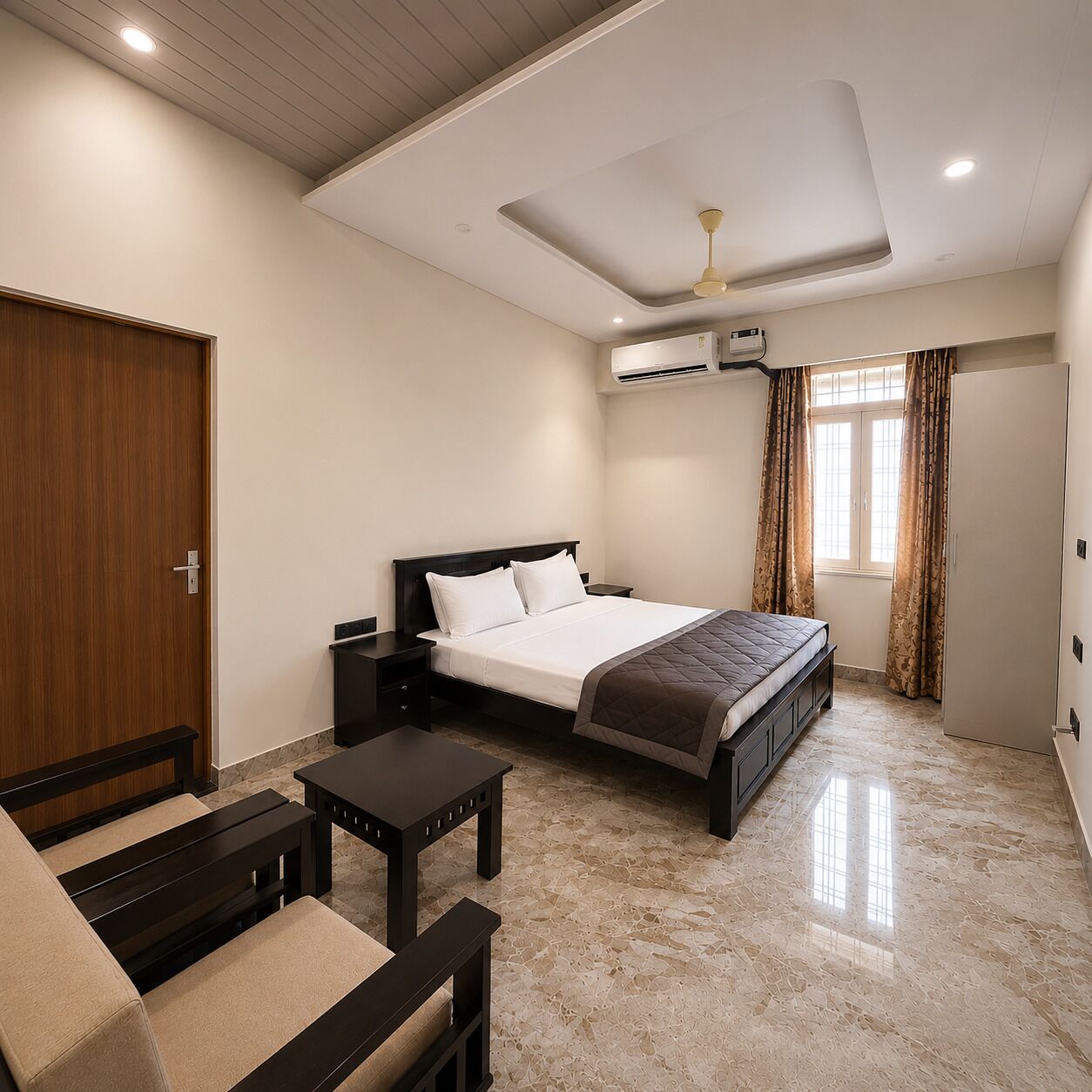 Une chambre d’hôtel équipée d’un lit, d’un canapé, d’une petite table, d’un ventilateur de plafond et d’un appareil de climatisation.