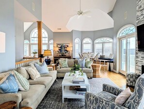 A spacious living room with a high ceiling, a central coffee table, and a sofa set. - 18 South Shore Drive - South Shore Marina (Bethany Beach)