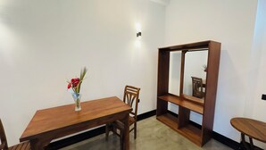 A dining area with a wooden table, chairs, and a vase with flowers. - Private 2 Bedroom Villa with 2 King Beds Near Unawatuna Beach (Unawatuna)