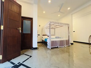 A hotel room with a wooden door, a bed with a canopy, a ceiling fan, and a tiled floor. - Private 2 Bedroom Villa with 2 King Beds Near Unawatuna Beach (Unawatuna)
