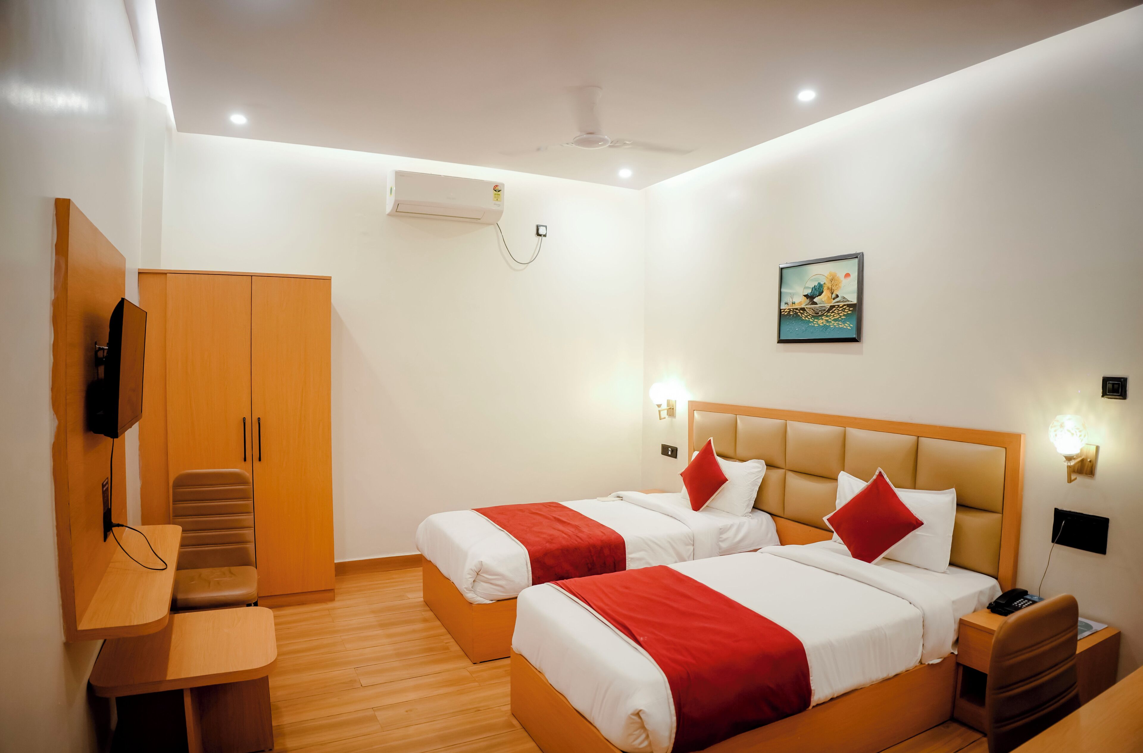 Habitación de hotel con dos camas, un escritorio, un armario y un ventilador de techo.