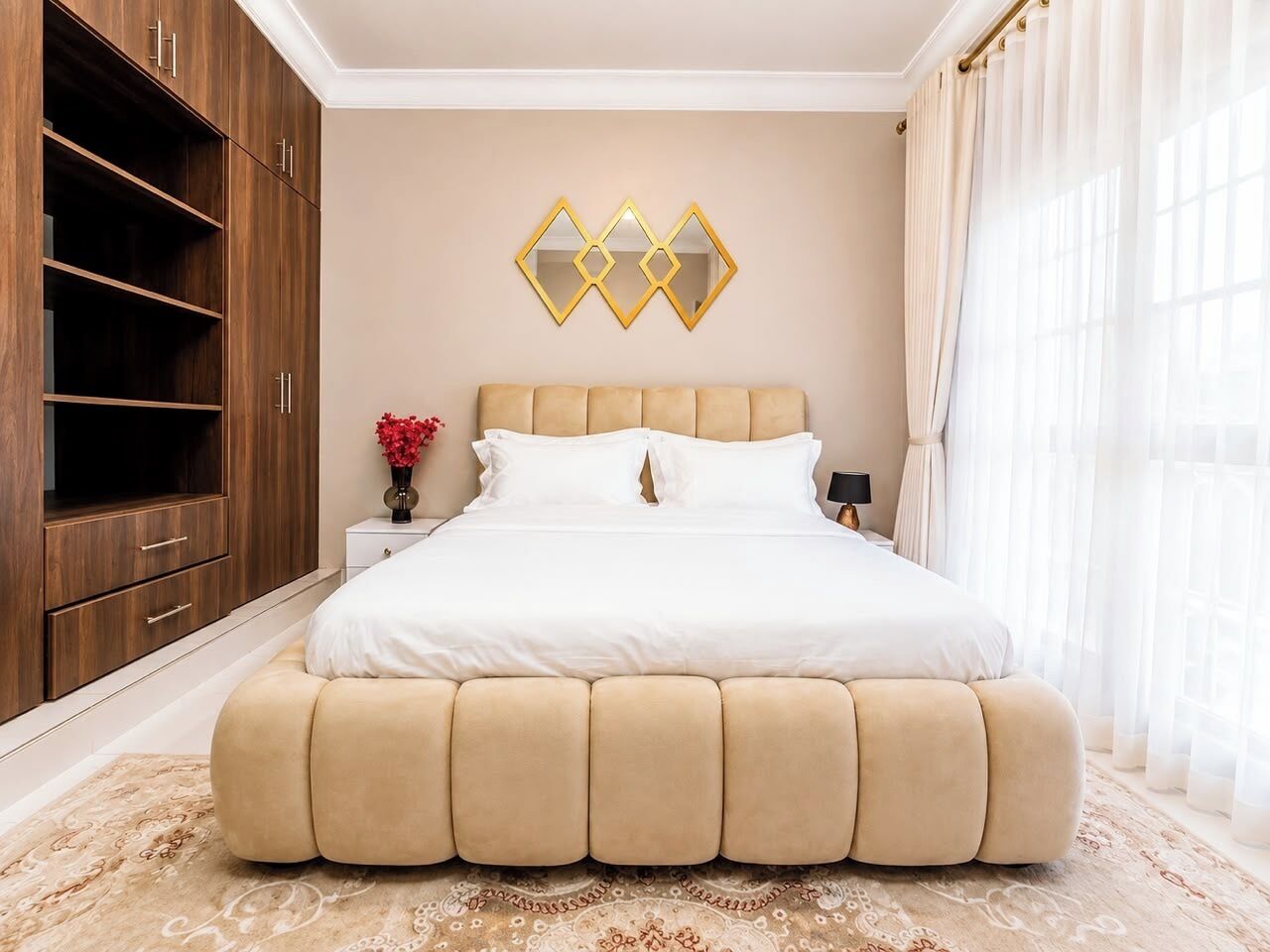 Ein Schlafzimmer mit einem großen Bett, einem Kleiderschrank, einem Nachttisch und einem dekorativen Spiegel an der Wand.