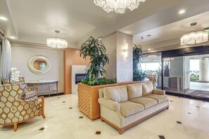 A lobby with a sofa, a decorative mirror, a potted plant, and a reception desk. - Extended La Jolla Escape Steps From the Coast (La Jolla)