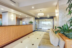 A hotel lobby with a reception desk, seating area, and a glass elevator. - Extended La Jolla Escape Steps From the Coast (La Jolla)