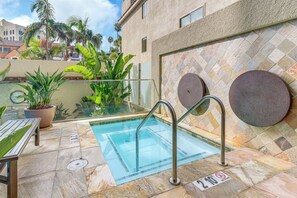 An outdoor swimming pool with a glass barrier, surrounded by potted plants and a tiled wall. - Extended La Jolla Escape Steps From the Coast (La Jolla)