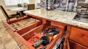 A kitchen with a marble countertop, a built-in drawer organizer, and a backsplash with various tiles. - Pool Table! Spacious Home, 8 Mi to Dtwn Commons (Sacramento)