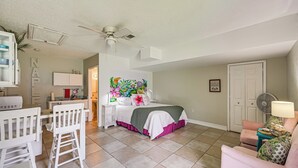 A bedroom with a bed, a desk, a chair, a ceiling fan, and a door. - Lanai, Pool Access! Naples Studio Near Beach (Naples)