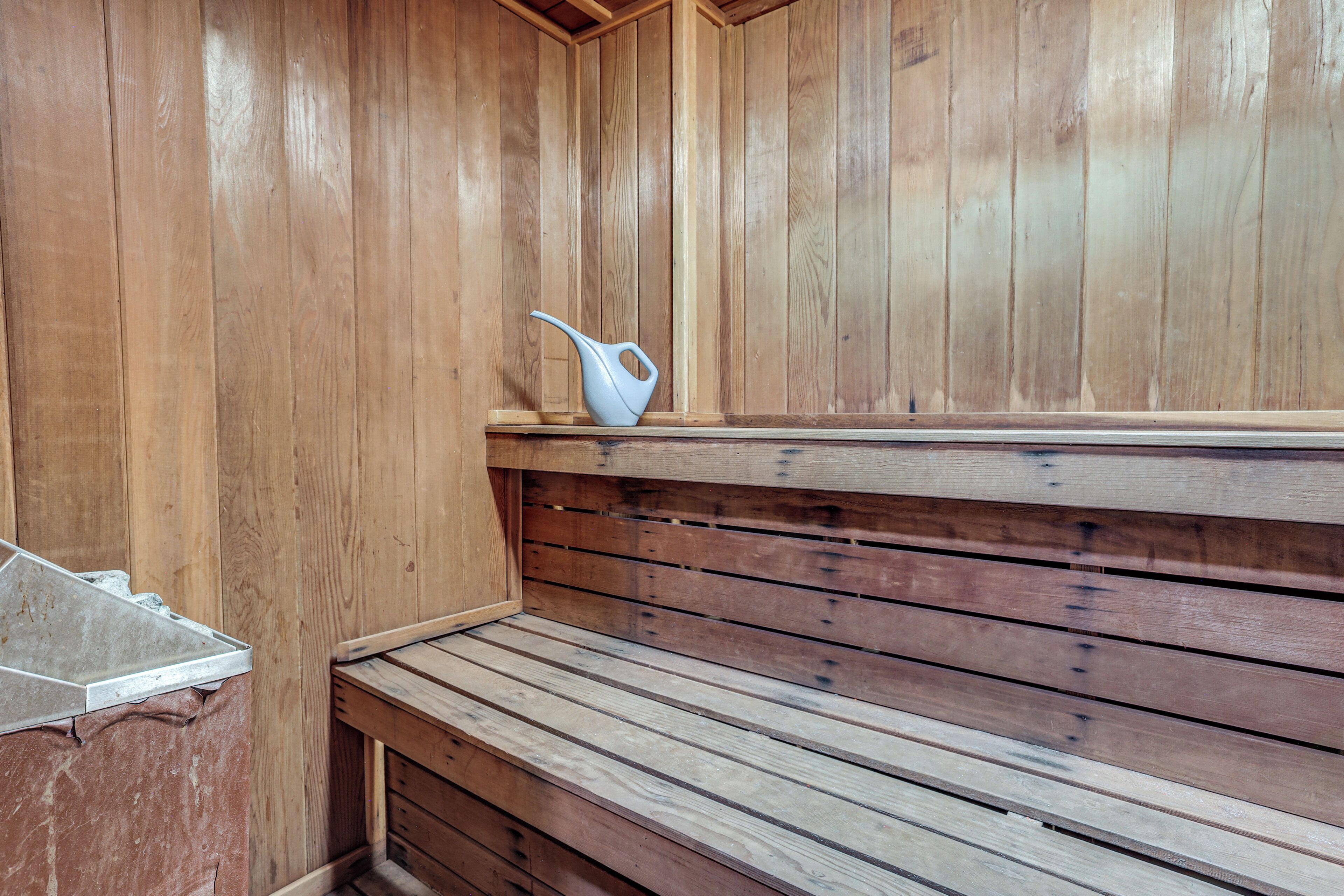 A wooden sauna bench with a white ceramic jug on top.