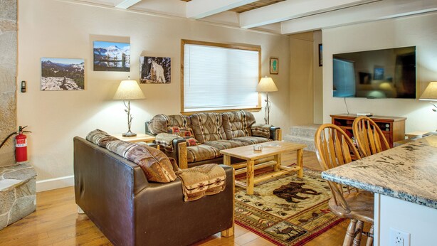 A living room with a sofa, coffee table, and chairs, a television, and framed pictures on the wall. - Minutes to Slopes & Shore! Cozy Cabin w/ hot tub (South Lake Tahoe)