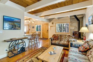 A cozy living room with a sofa, a coffee table, and a fireplace. - Minutes to Slopes & Shore! Cozy Cabin w/ Hot Tub (South Lake Tahoe)
