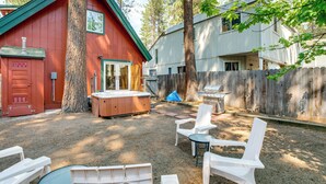 A backyard with a hot tub, outdoor seating, and a wooden fence. - Minutes to Slopes & Shore! Cozy Cabin w/ hot tub (South Lake Tahoe)