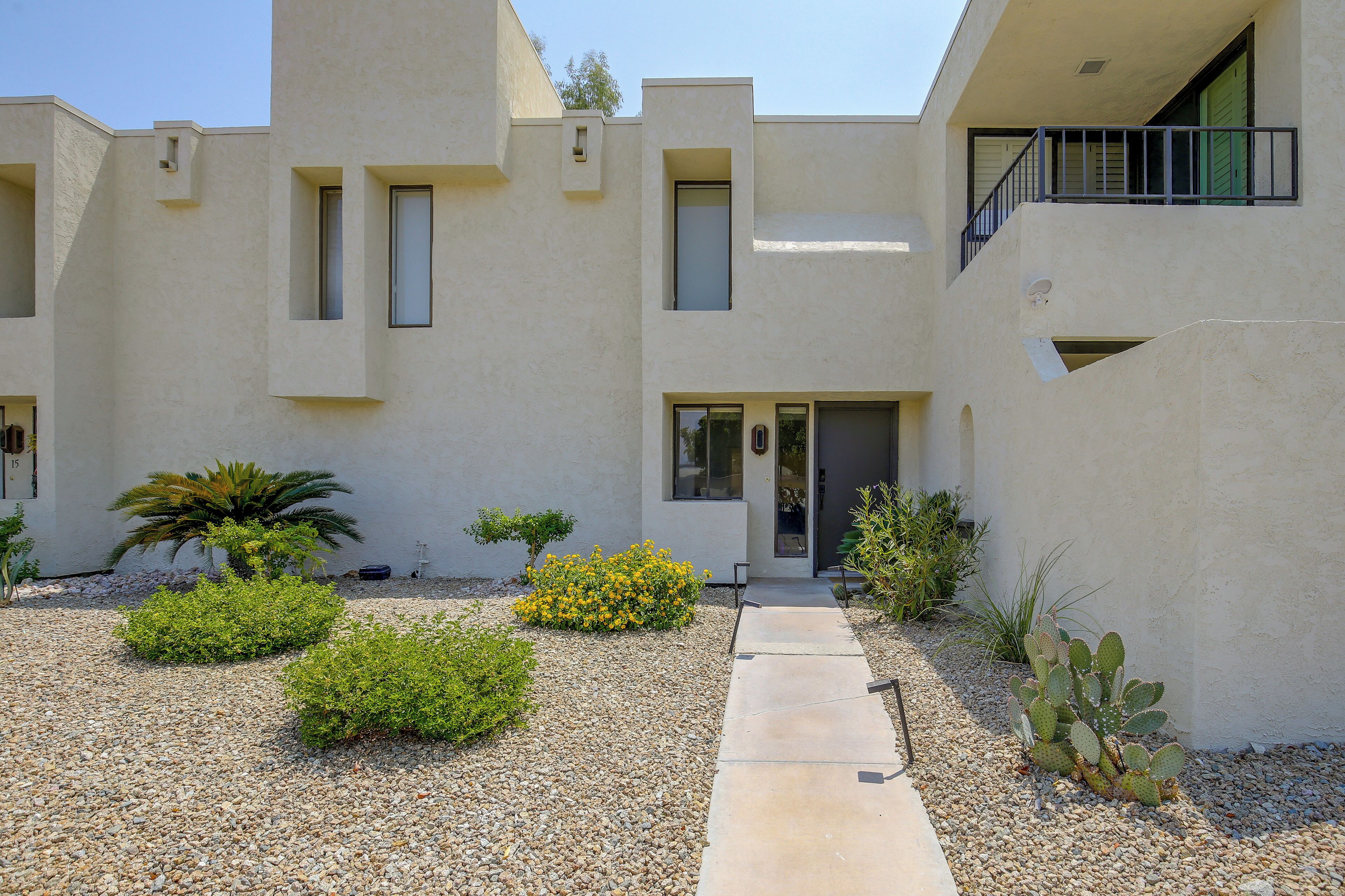 A modern building with a flat facade, multiple windows, and a small entryway.