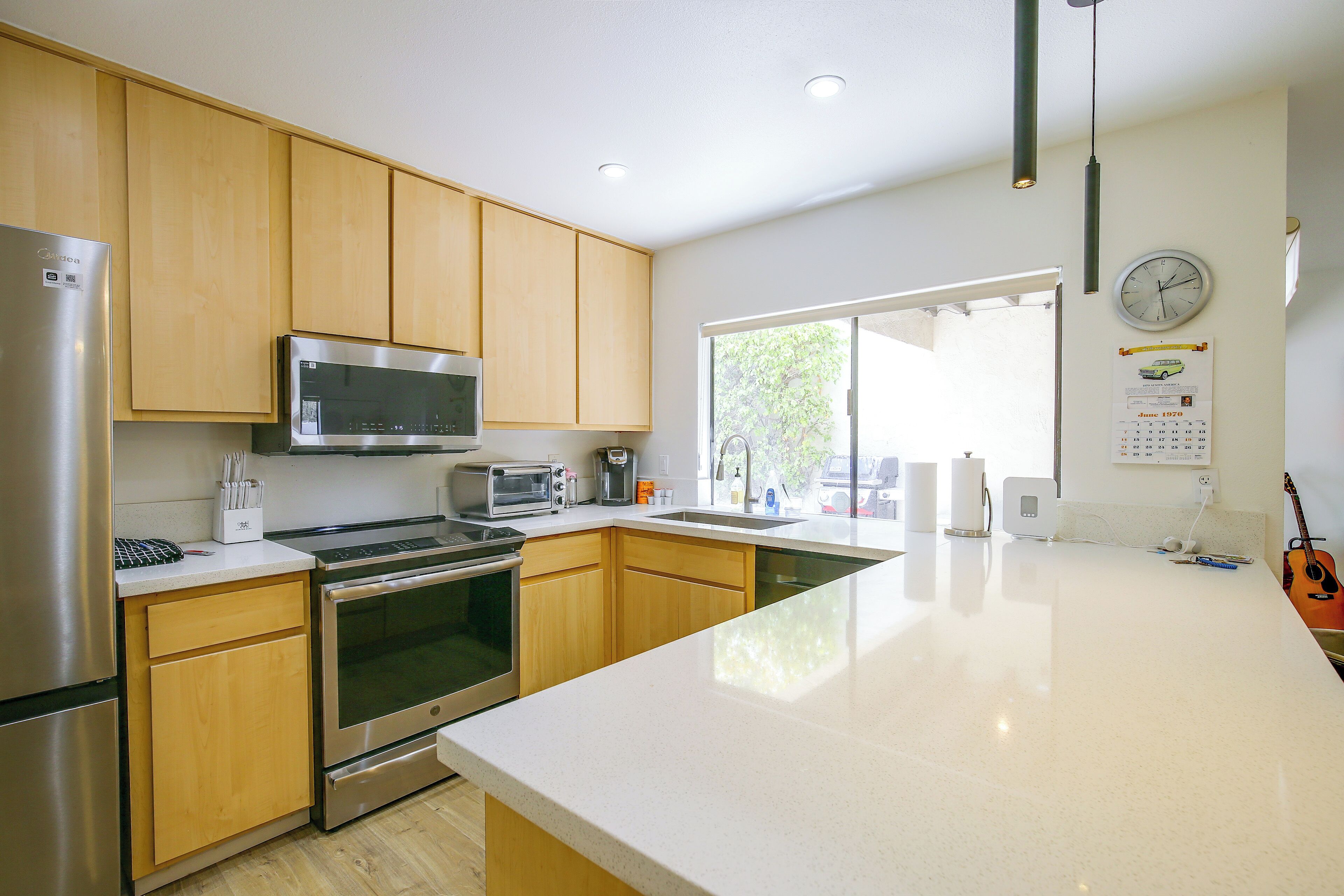 Una cocina moderna con electrodomésticos de acero inoxidable, armarios de madera y un amplio ventanal que proporciona luz natural.