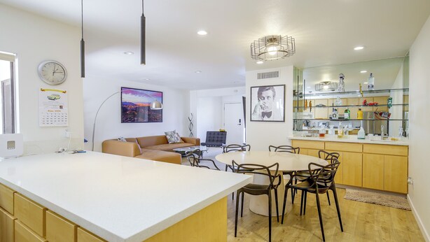 A modern kitchen with a central island, dining area with chairs, and a living space with a sofa. - Walk to El Paseo Shops! Palm Desert Condo w/ Patio (Palm Desert)