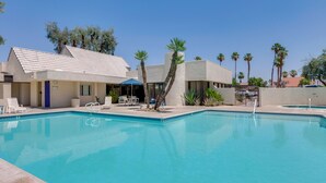 A swimming pool with lounge chairs and a building with a tiled roof. - Walk to El Paseo Shops! Palm Desert Condo w/ Patio (Palm Desert)