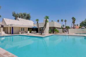 A swimming pool with lounge chairs and a building with a tiled roof. - Walk to El Paseo Shops! Palm Desert Condo w/ Patio (Palm Desert)