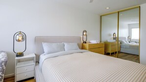 A bedroom with a bed, bedside tables, a wardrobe, and a ceiling fan. - Walk to El Paseo Shops! Palm Desert Condo w/ Patio (Palm Desert)