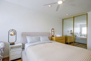 A bedroom with a bed, bedside tables, a wardrobe, and a ceiling fan. - Walk to El Paseo Shops! Palm Desert Condo w/ Patio (Palm Desert)