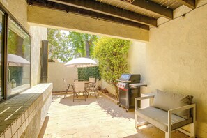 An outdoor patio with a grill, a table with chairs, and a cushioned bench. - Walk to El Paseo Shops! Palm Desert Condo w/ Patio (Palm Desert)