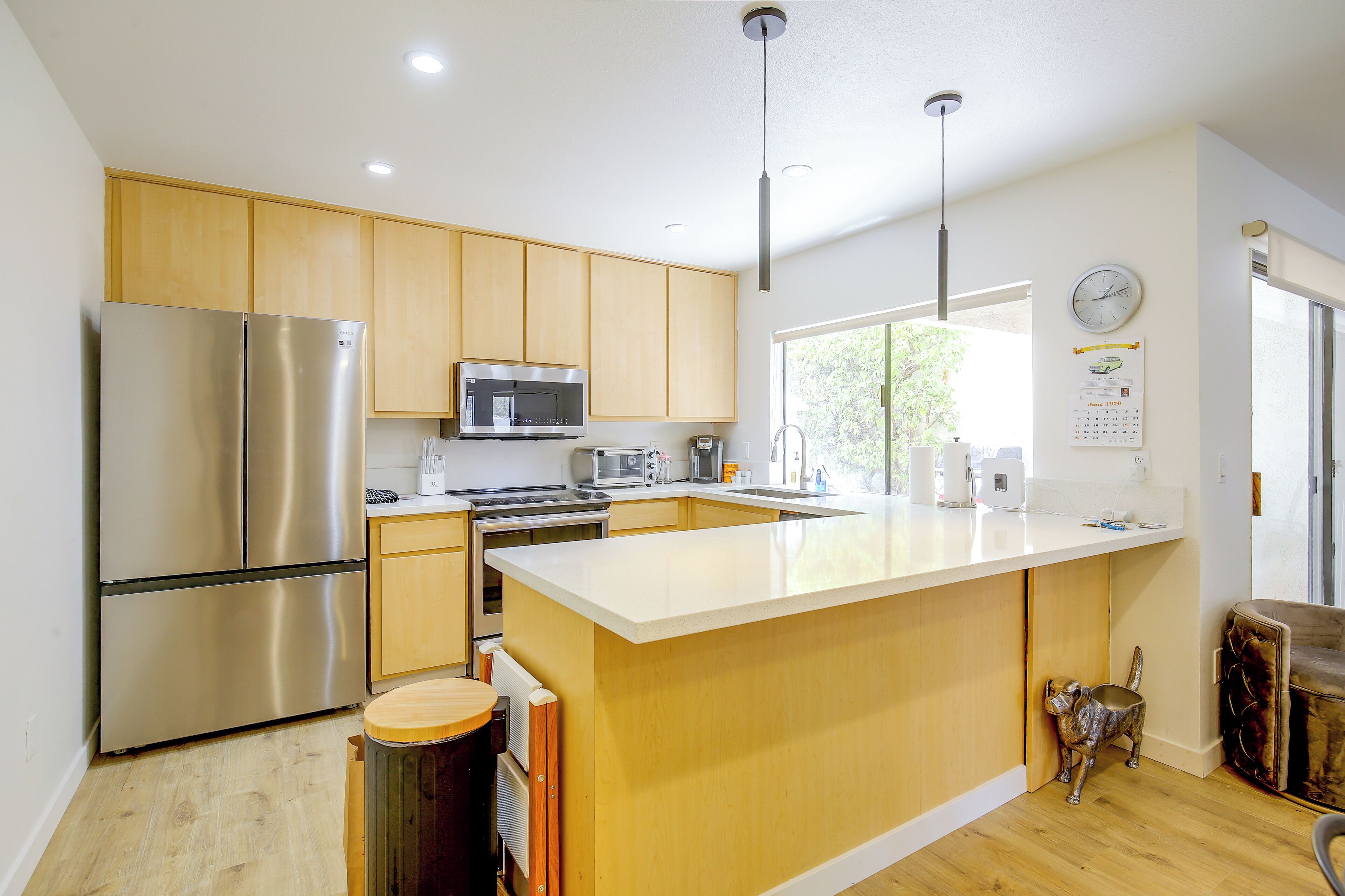A modern kitchen with stainless steel appliances, wooden cabinets, and a large island.
